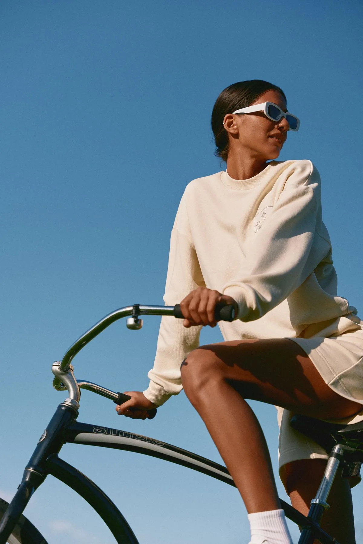 Woman on a bicycle under a clear blue sky